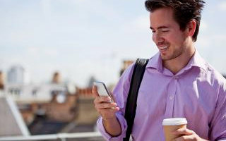 Un hombre revisa su teléfono móvil, fabricado con plásticos de policarbonato y BPA.