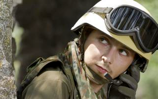Un soldado con equipo de protección que usa policarbonatos, incluidas gafas de seguridad, casco y chaqueta Kevlar.